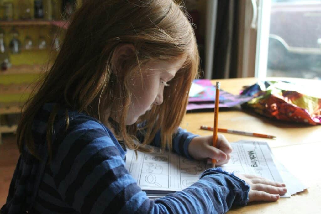 young school girl doing homework frown