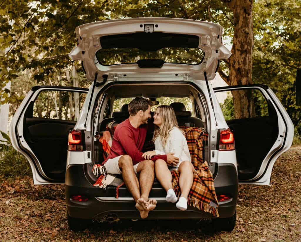 couple sitting in back of car suv date