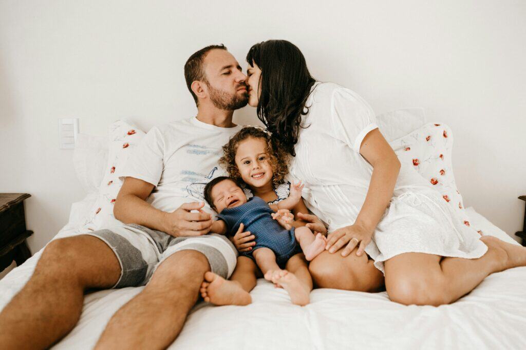 Mom dad and two small kids on bed