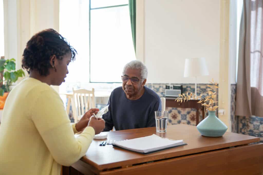 daughter helping elderly father with medication