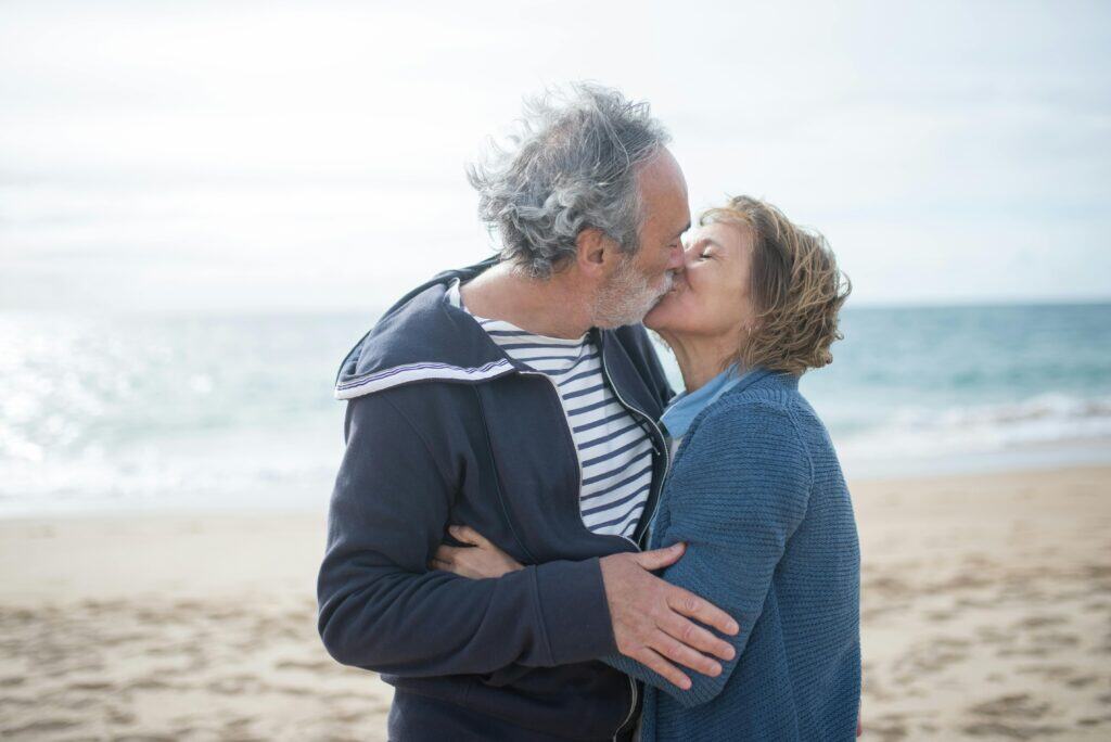 older couple kissing on beach