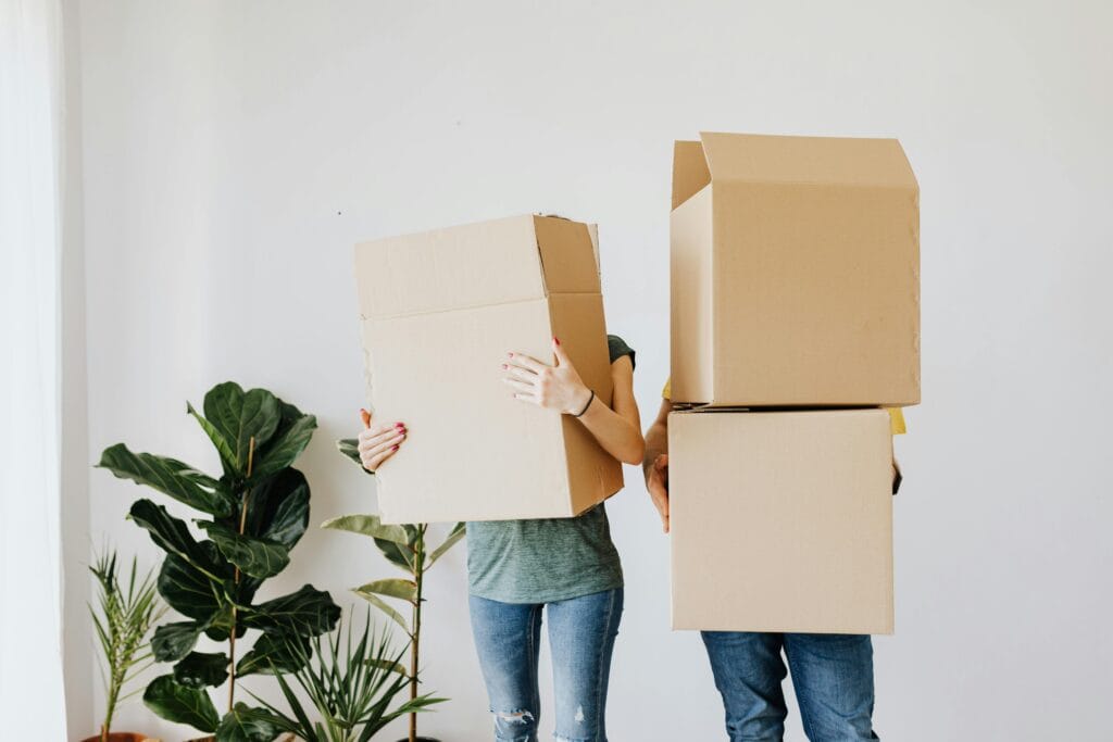 couple side by side faces covered with moving boxes