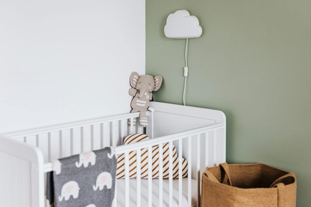 empty crib with stuffed animal and blanket