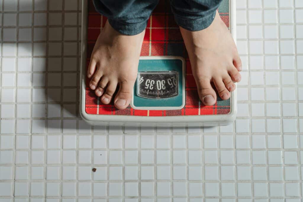 child standing on bathroom scale