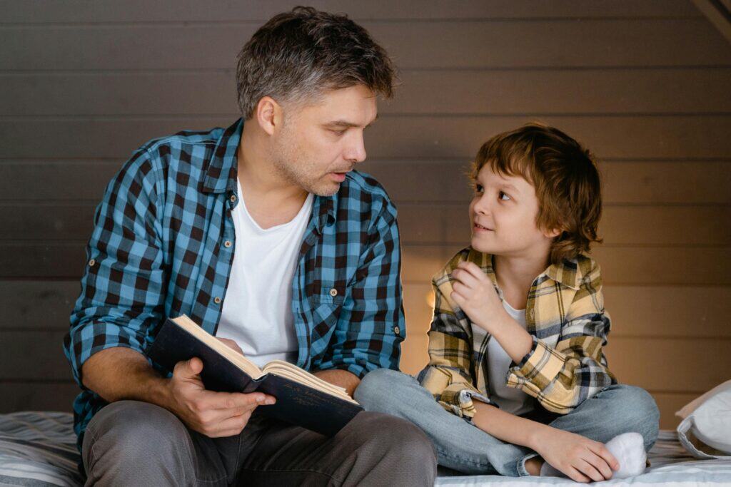 Dad holding book talking to son