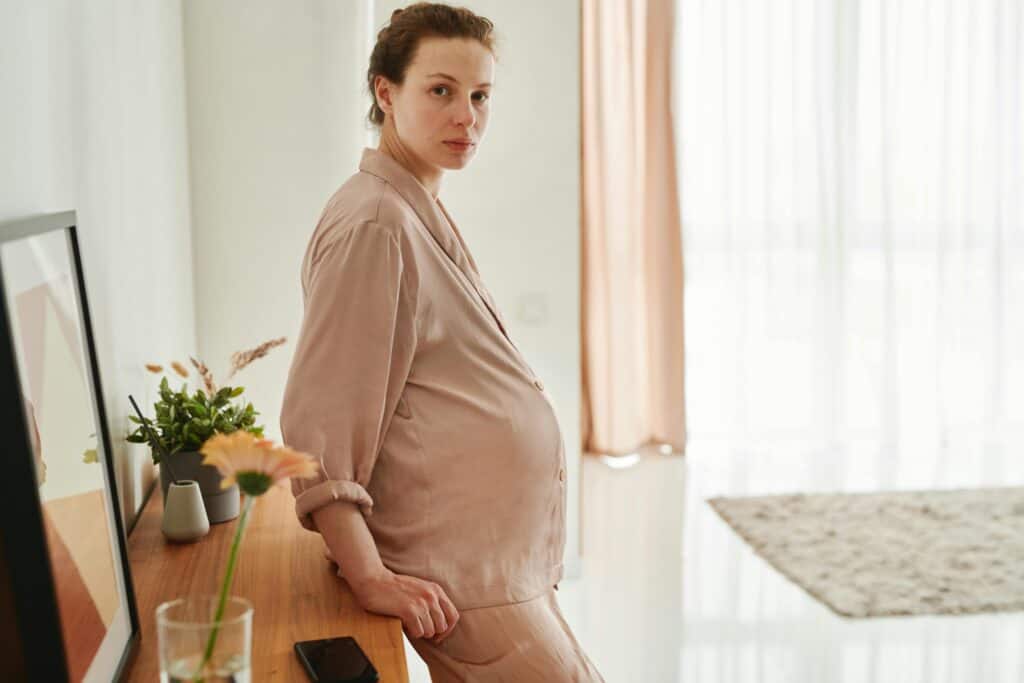 Pregnant woman looking serious in pajamas