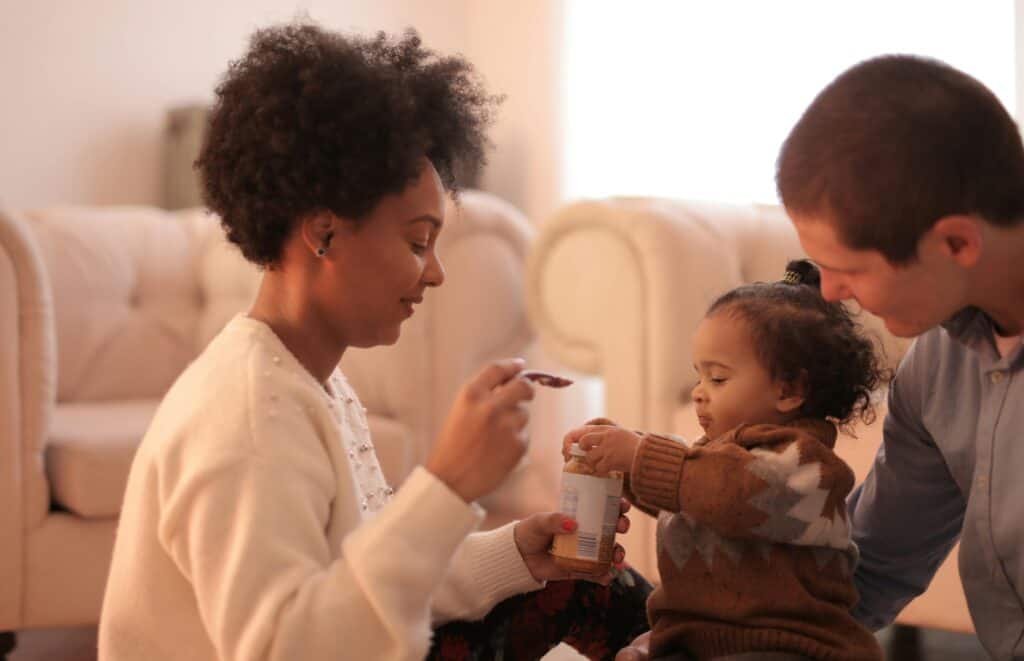 parents feeding toddler
