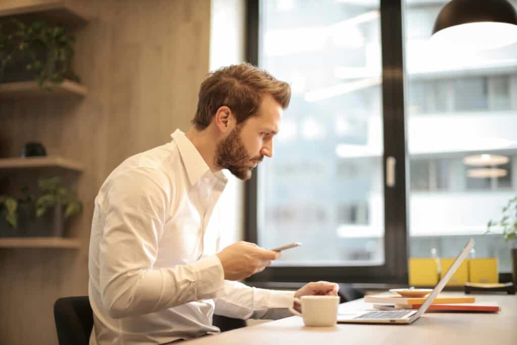 man on cell and computer
