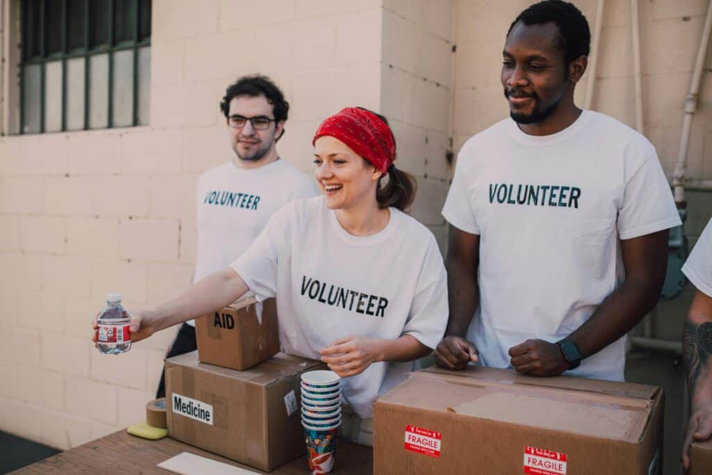 people in volunteer shirts passing out food