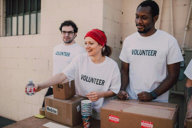 people in volunteer shirts passing out food