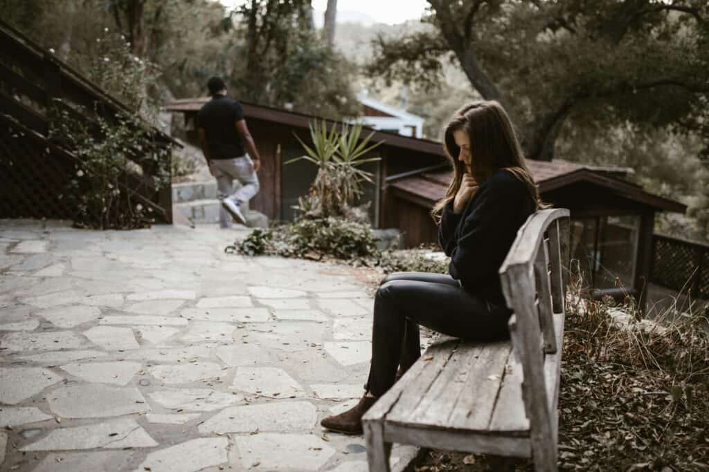 woman on bench sad man walking away
