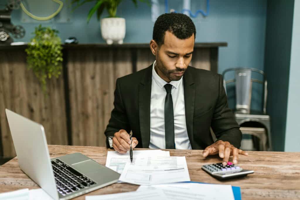 man in suit with computer and calculator goals