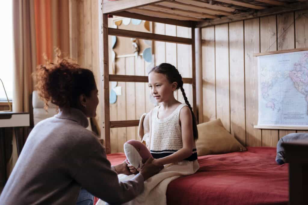 mom and daughter talking in bedroom
