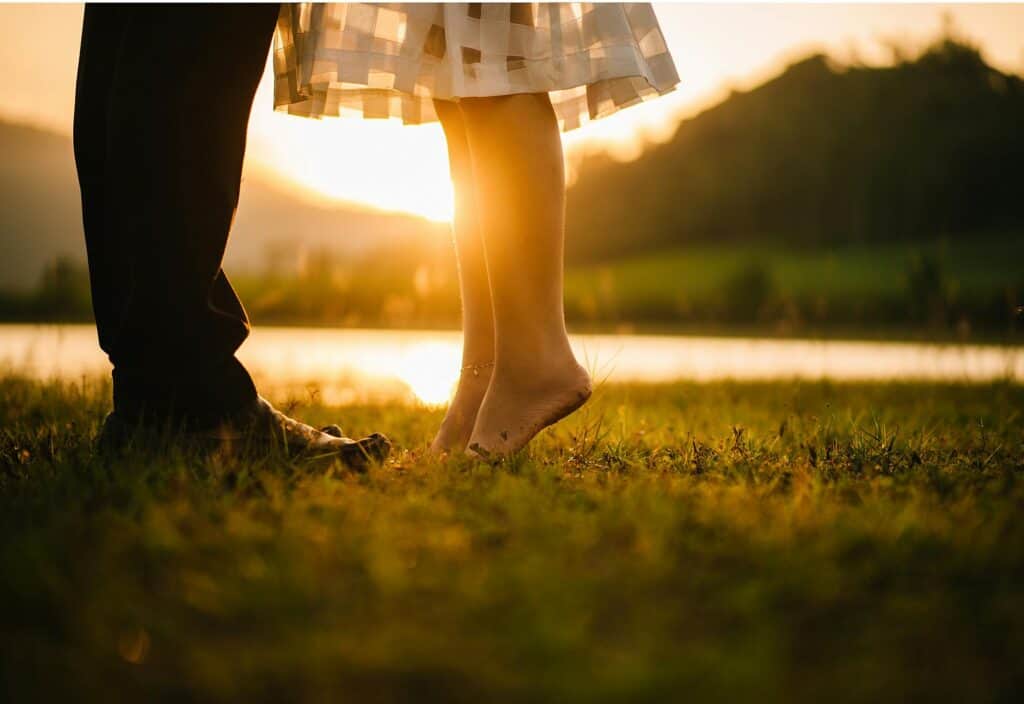 man and woman feet sunset in background