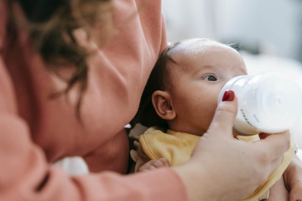 woman bottle feeding baby