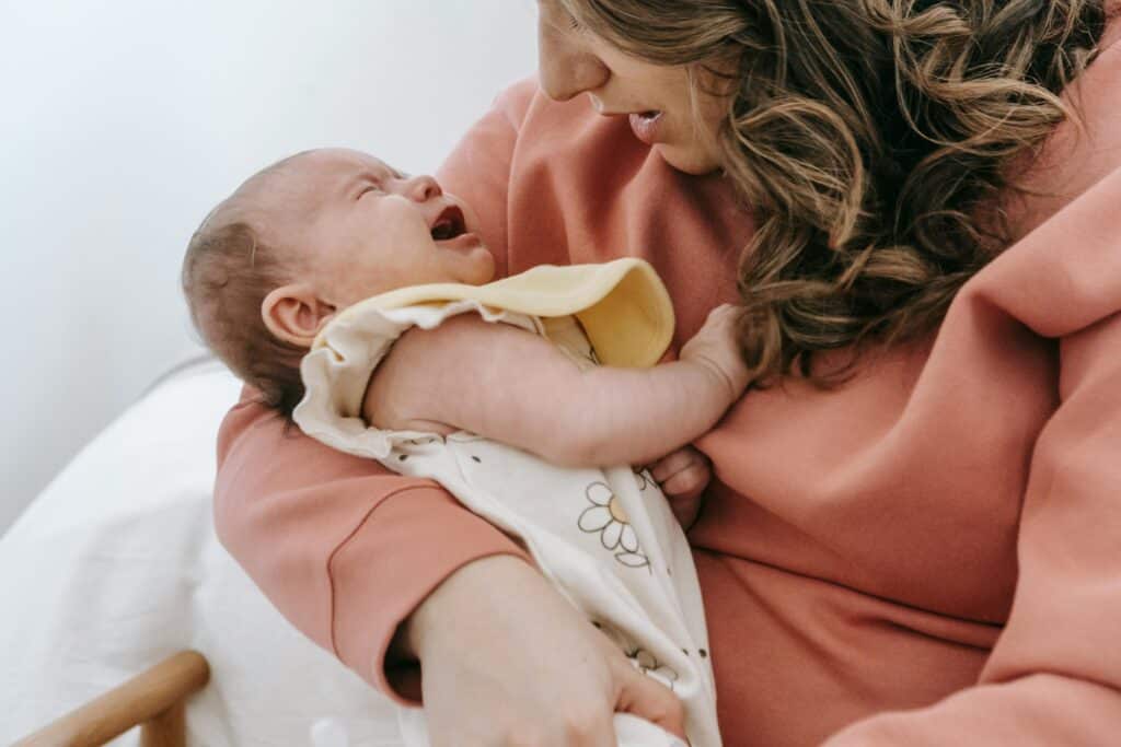 woman holding crying baby