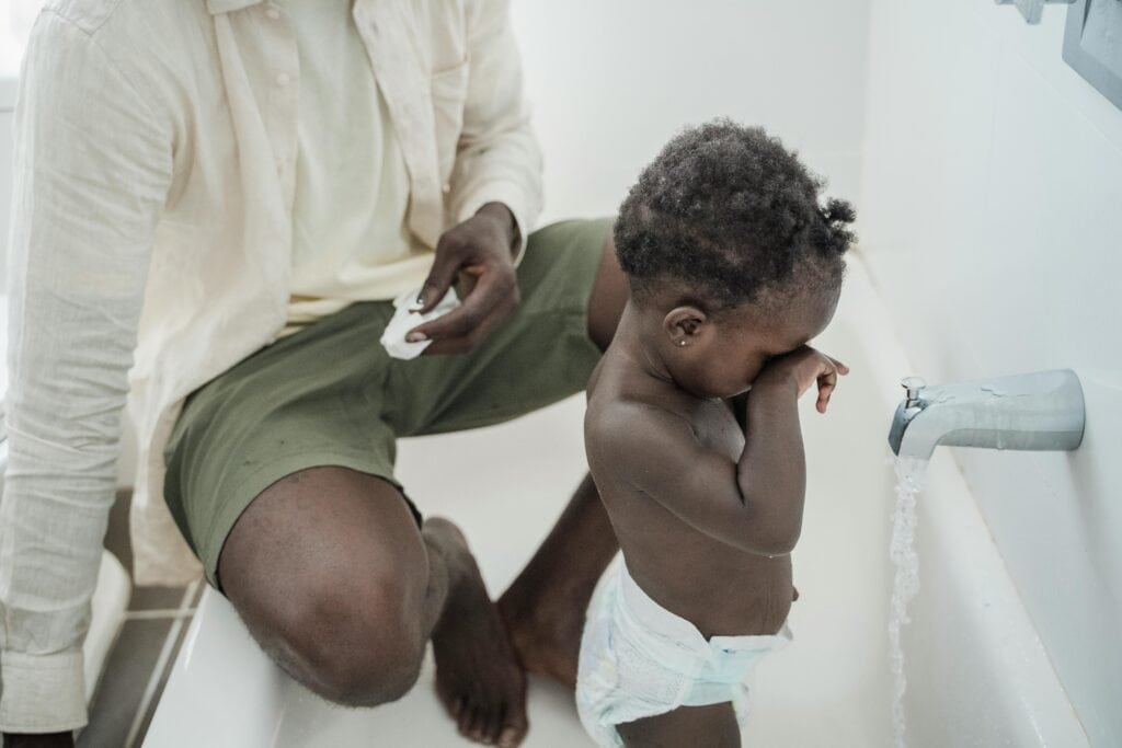 dad helping give toddler bath
