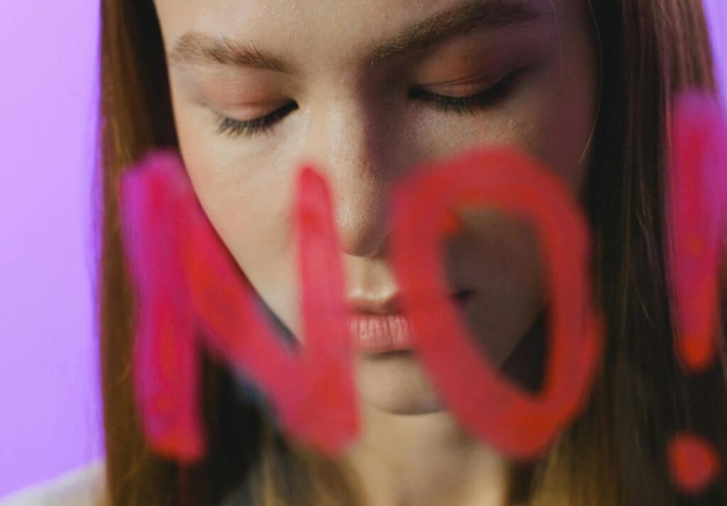 Teen girl behind glass with the word no