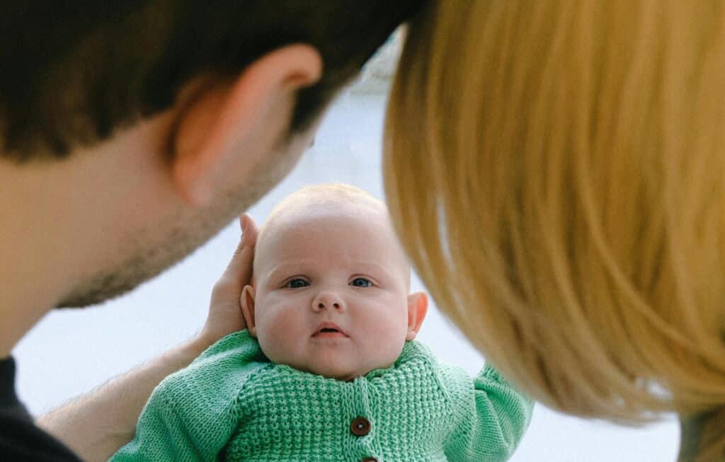 backs of parents' heads looking at baby