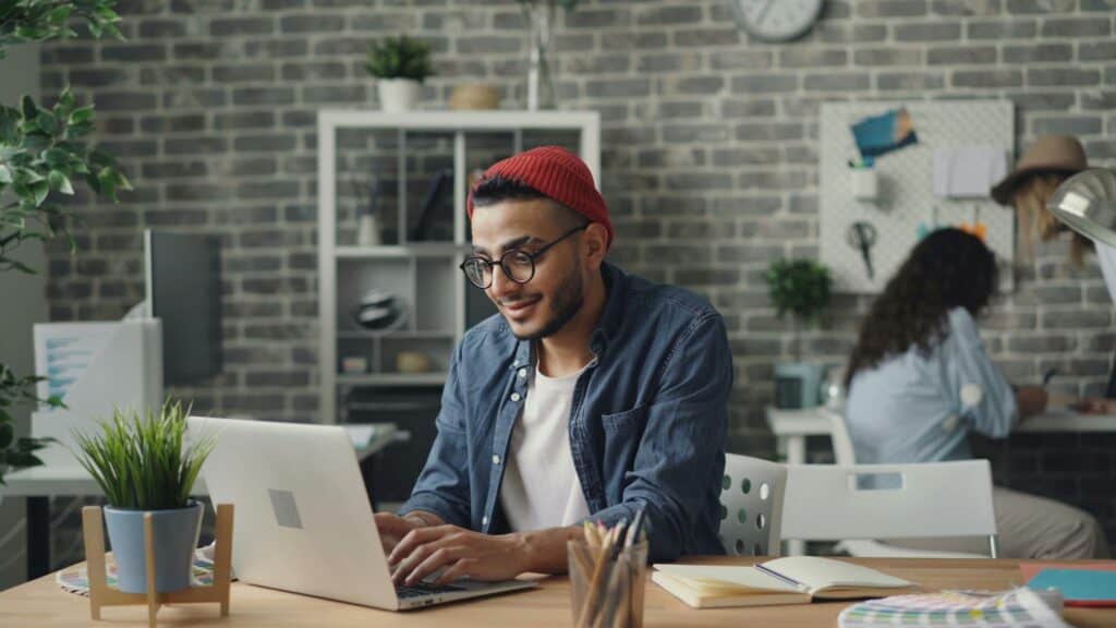 20 something guy smiling looking at computer