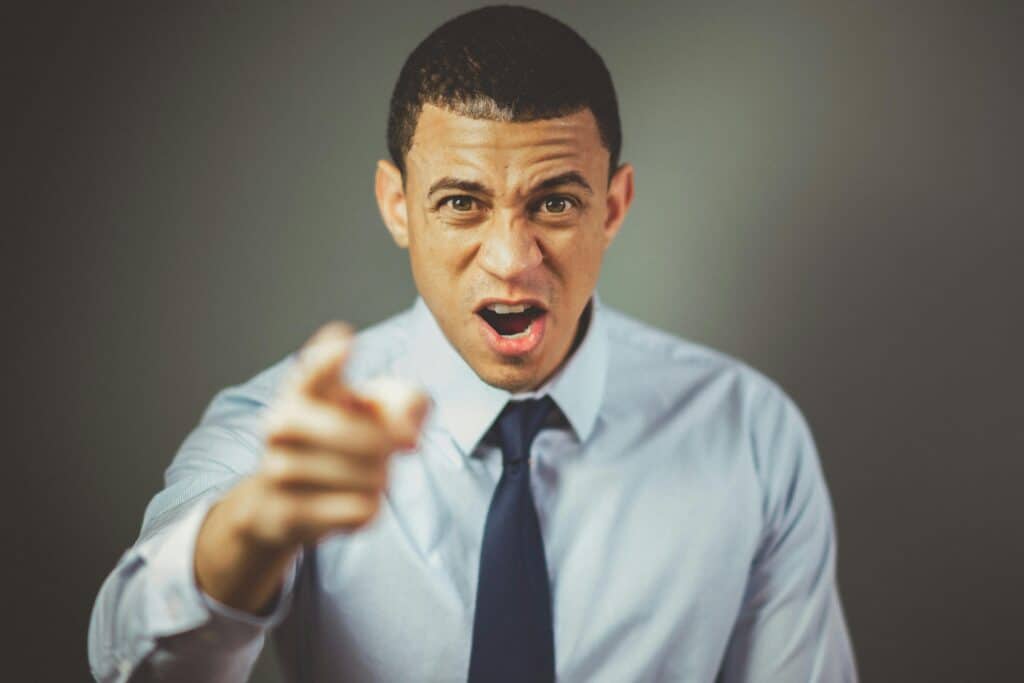 man in shirt and tie angry pointing finger at camera