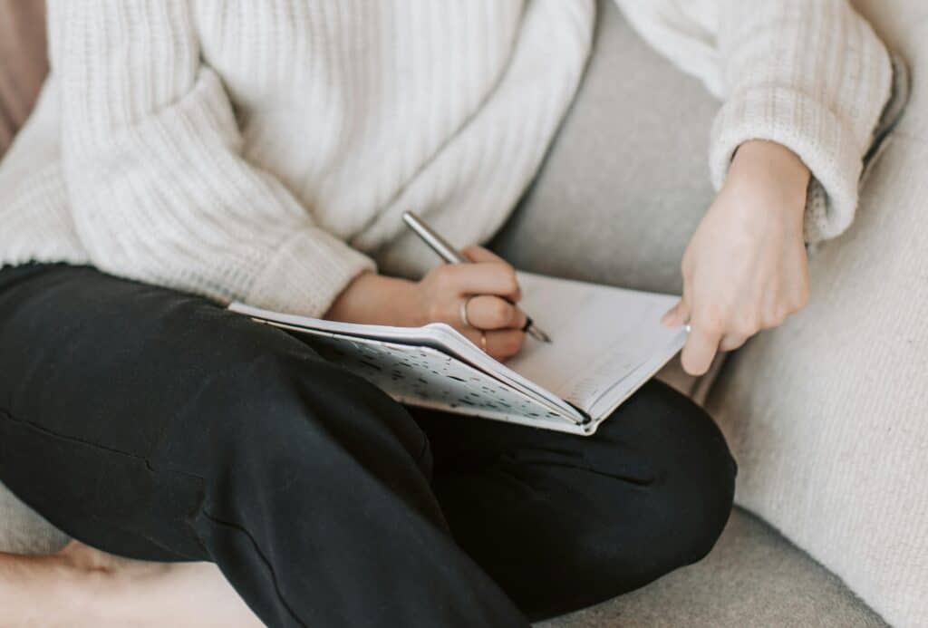 woman writing in a journal hands