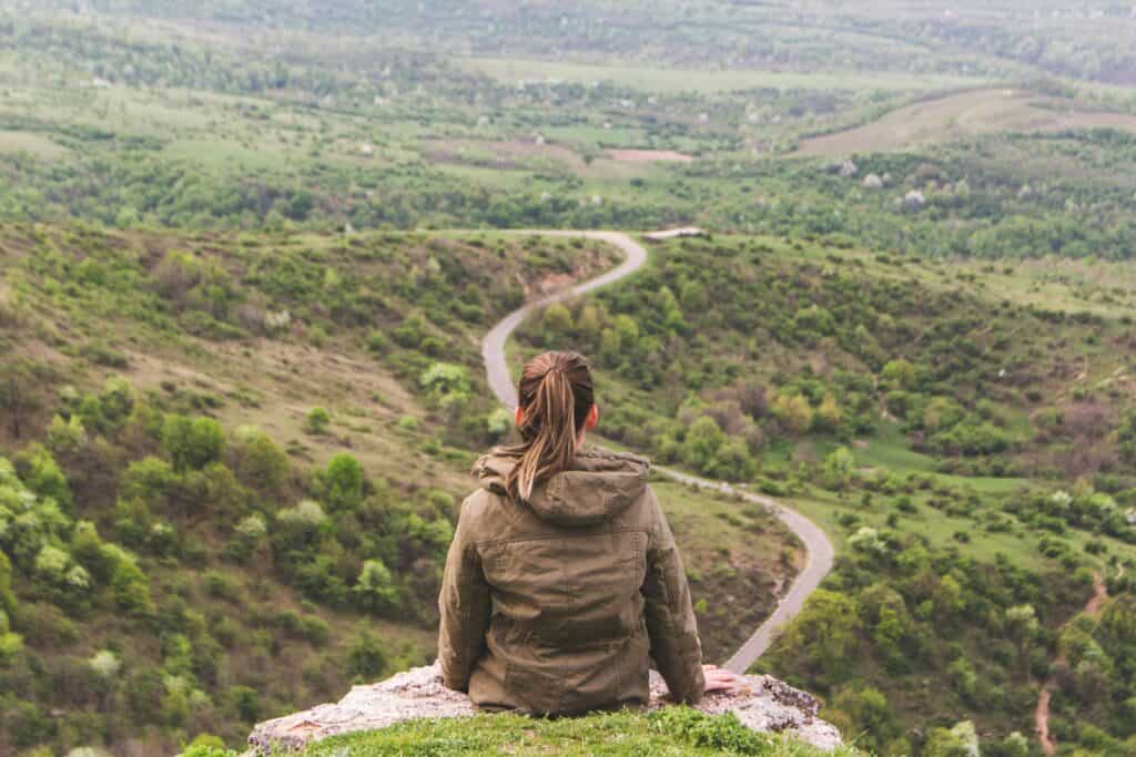 girl on hill looking out on road in front of her