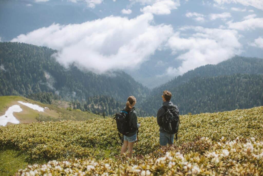couple with backpacks exploring mountains