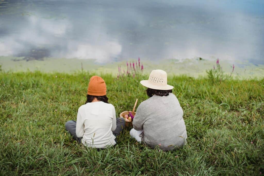 back of mom and daughter wearing hats in field