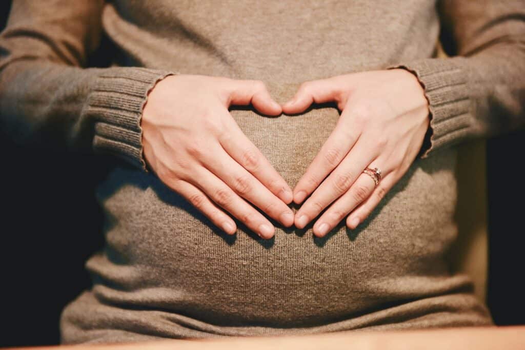 pregnant woman making heart with hands
