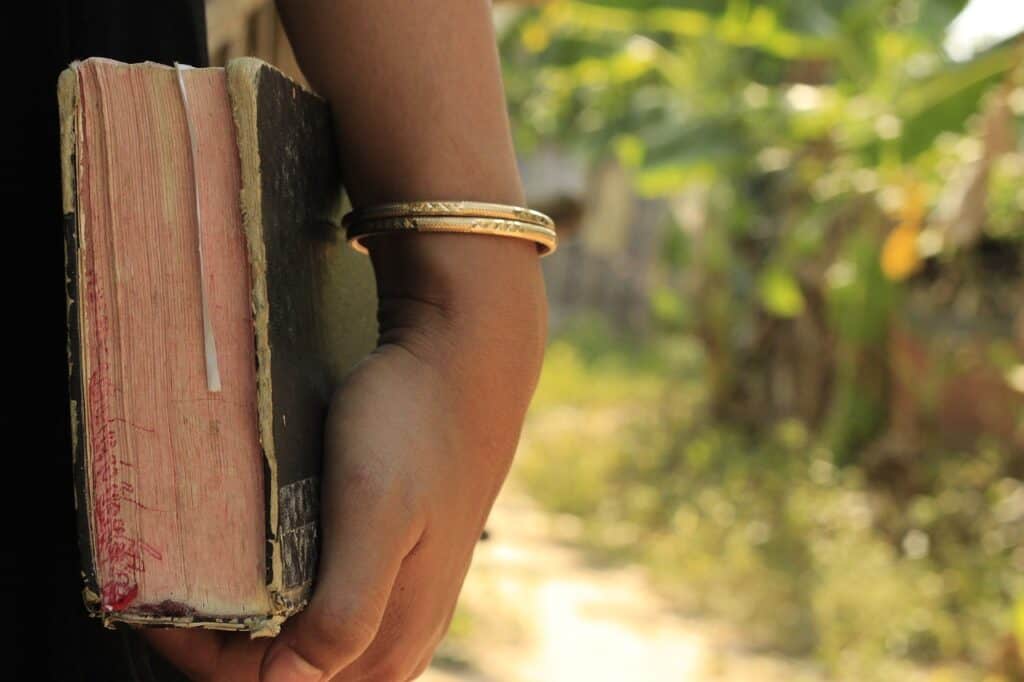 teen girl hand holding Bible