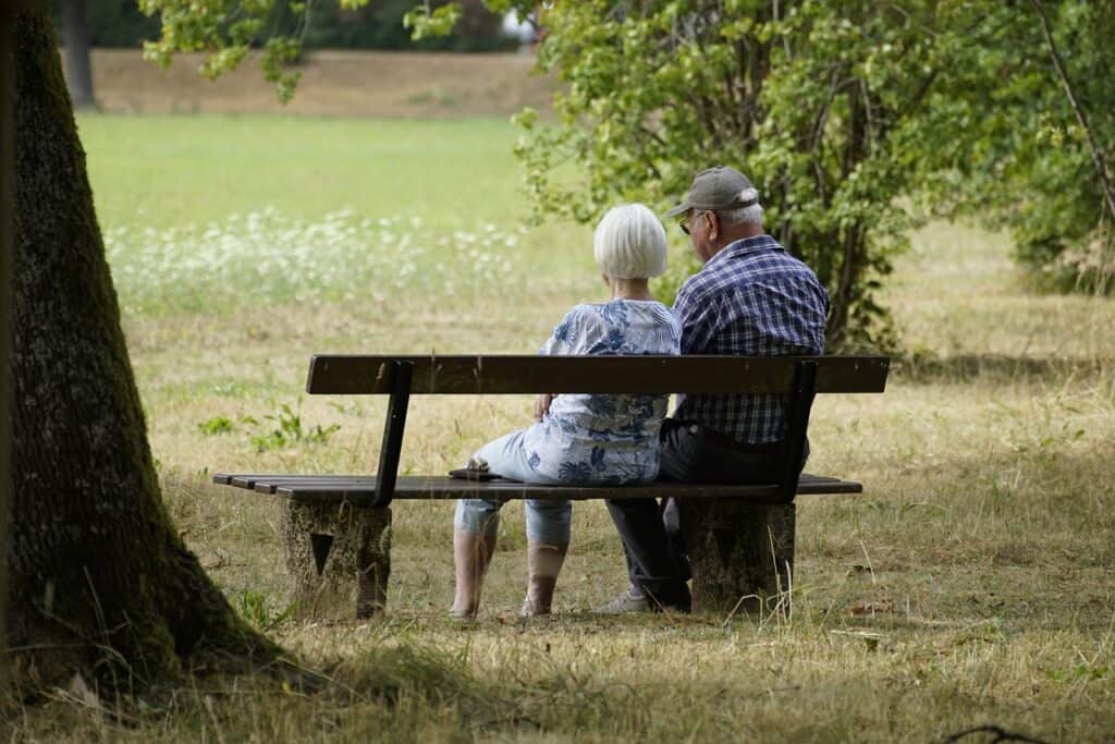 Elderly couple sitting on park bench