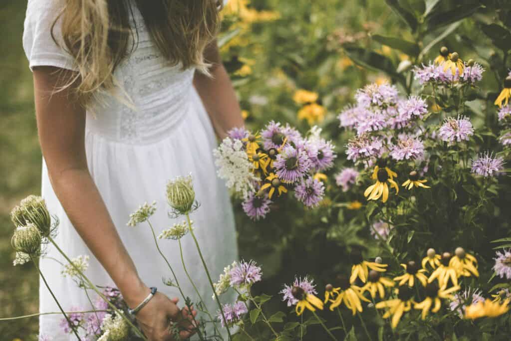girl in dress picking flowers
