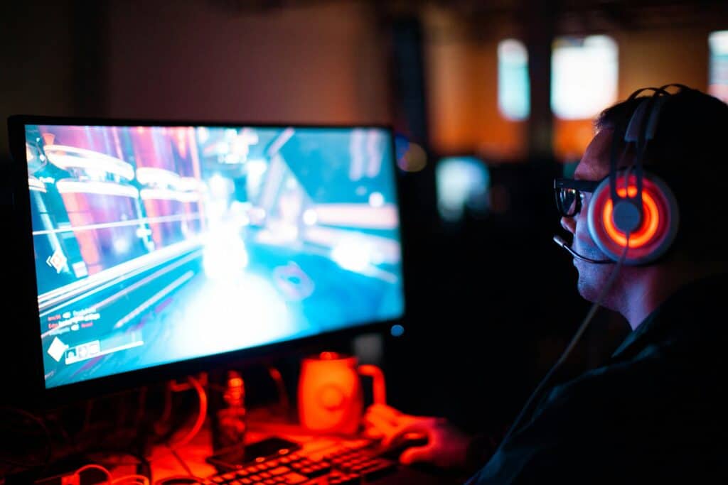 man playing video game on computer in dark