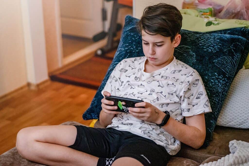 boy playing hand held video game