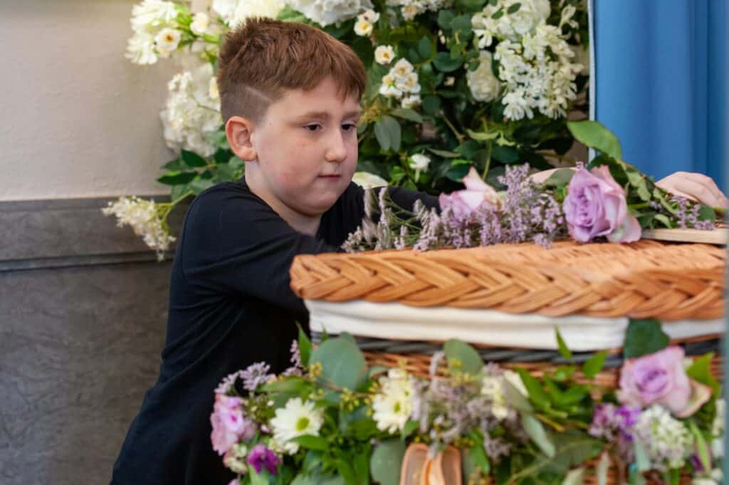 boy by coffin