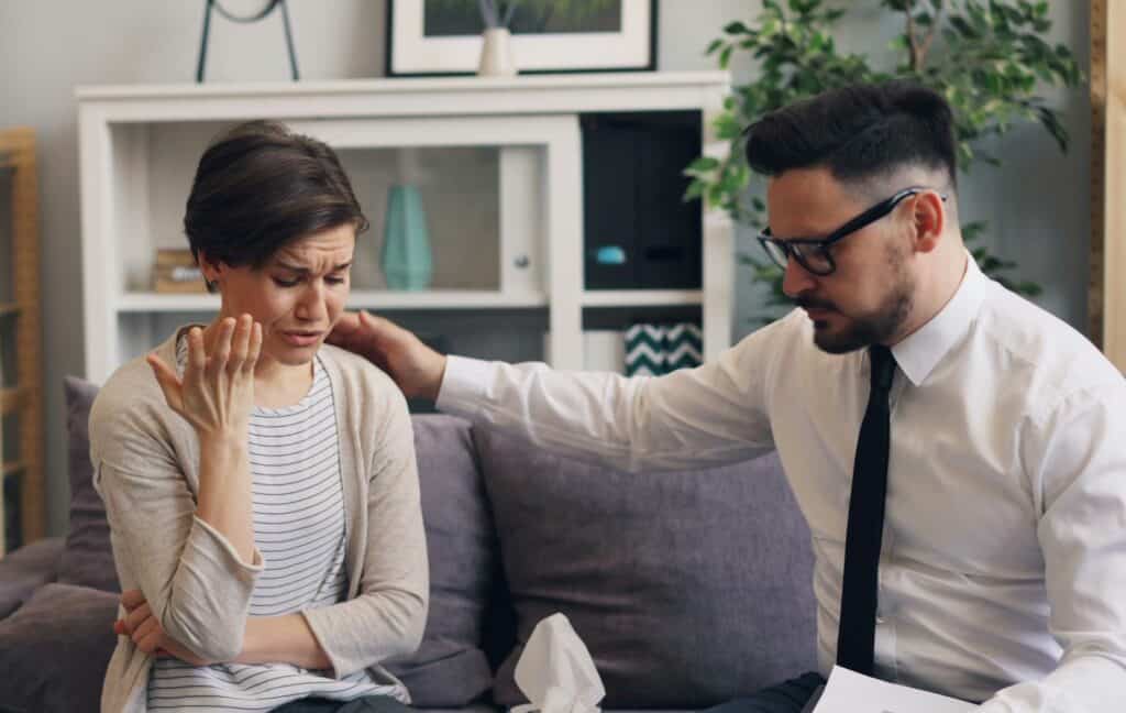 woman crying man with arm on her shoulder