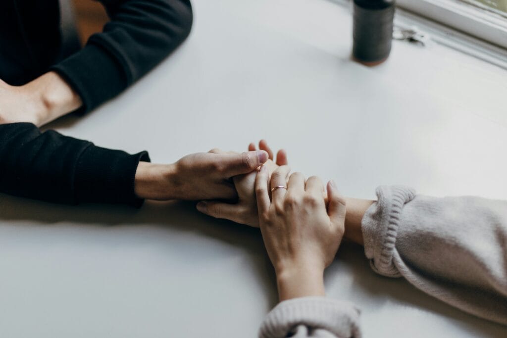 young husband and wife holding hands across the table