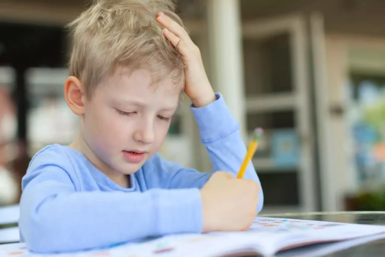 Learning styles matter. Little boy in a blue long sleeved shirt struggling over his homework.