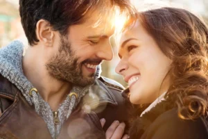 A husband and wife are embracing each other with smiles on their faces as they look into each others' eyes, demonstrating the importance of making your spouse feel cherished.