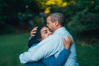 A couple embraces tenderly in a peaceful outdoor setting, reflecting the emotional journey of being diagnosed with cancer and finding strength together.