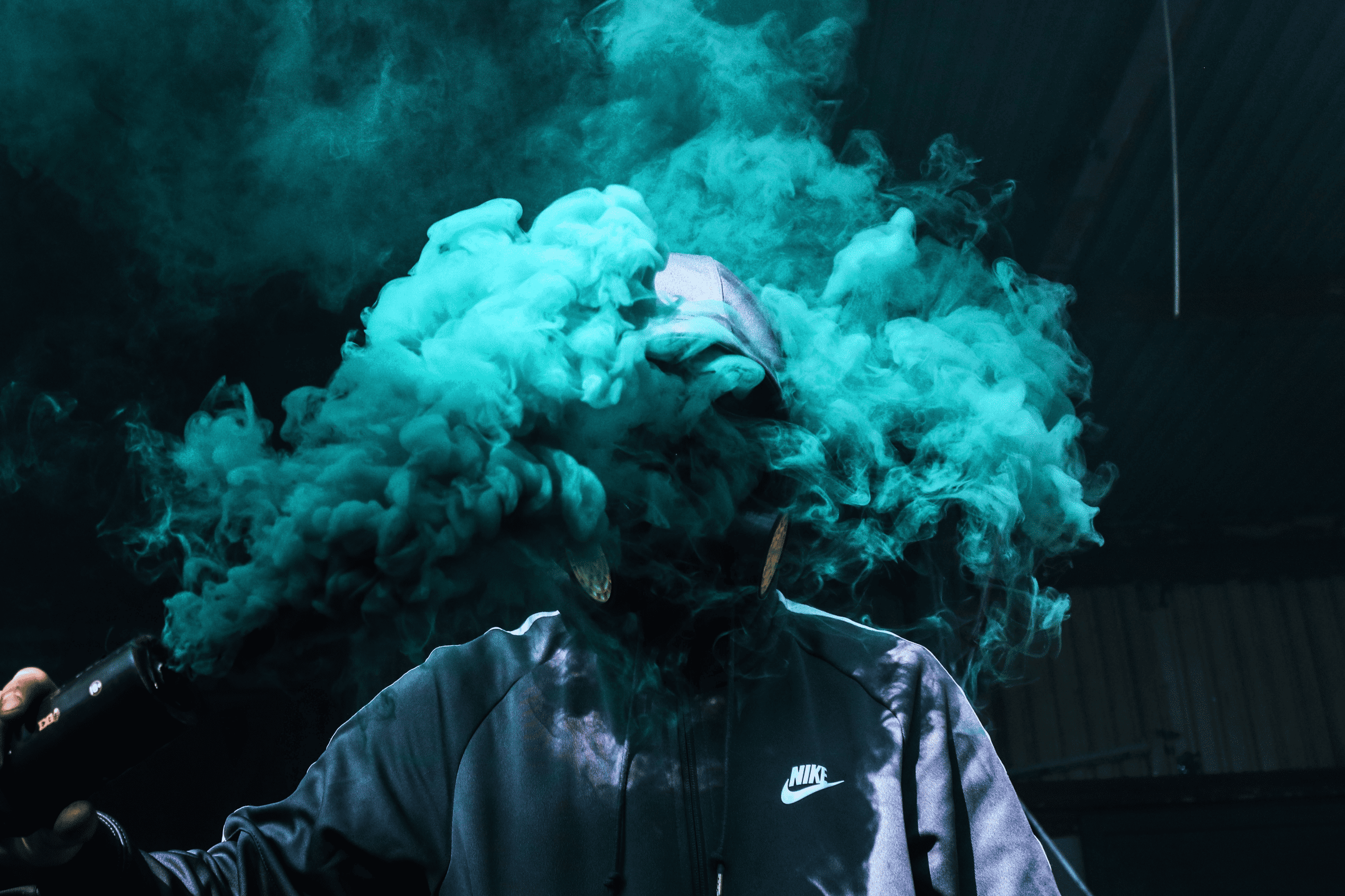 a masked man holds a smoke grenade