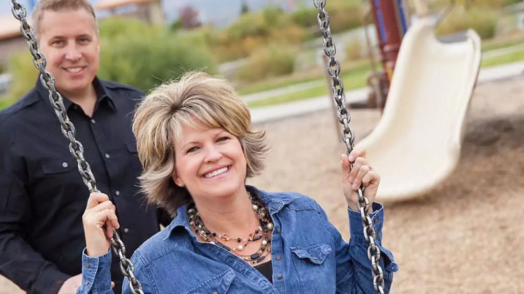 photo of Dr. Greg Smalley pushing his wife Erin on the swings. They have a love that has and will last a lifetime.
