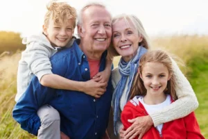Grandparents smiling as they hold grandson and granddaughter
