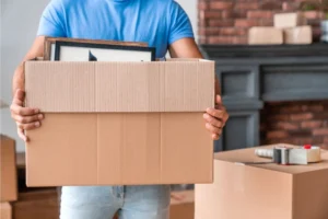 Teenage boy carrying a moving box