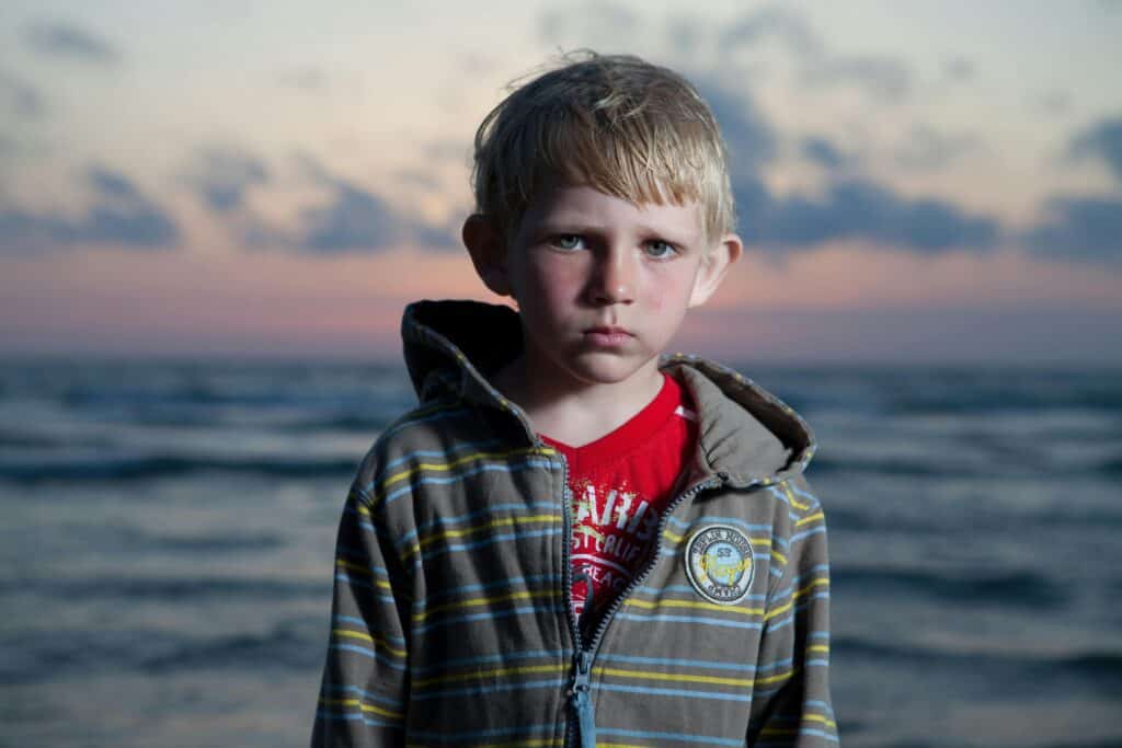 angry looking boy with sunset in background