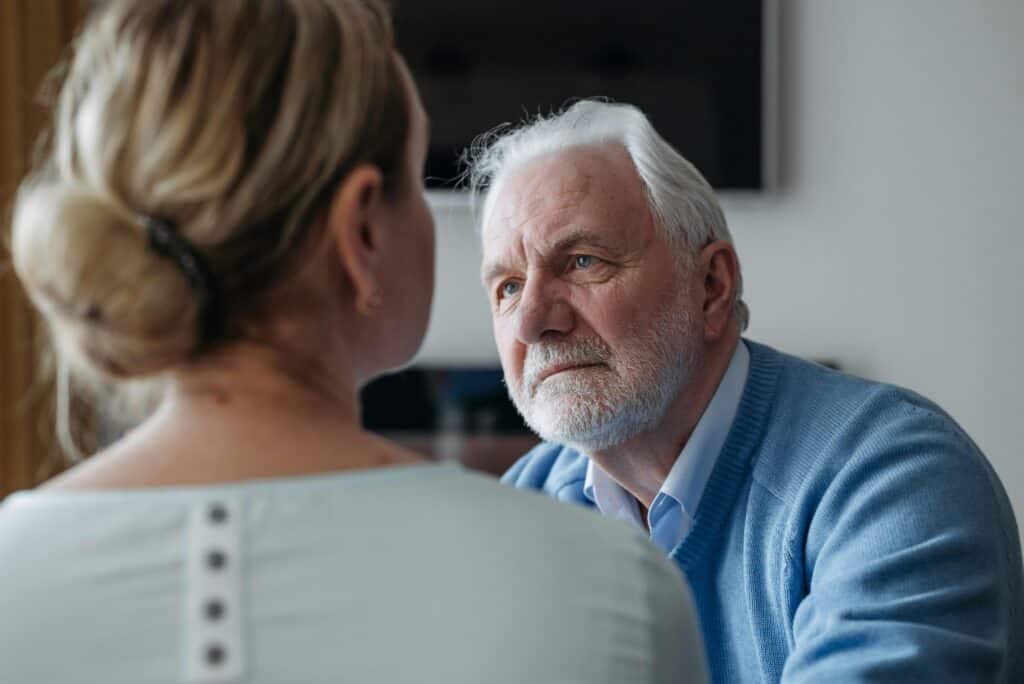 older man looking at woman in foreground