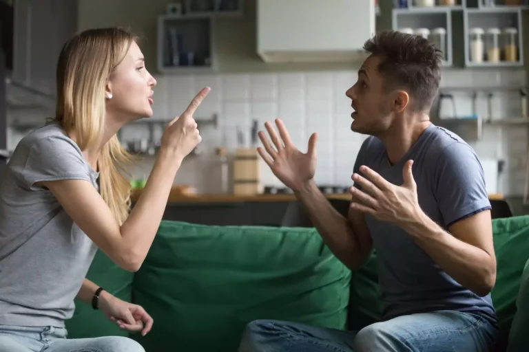 A young husband and wife argue on a couch. Here's a a practical process of healthy conflict resolution in marriage.
