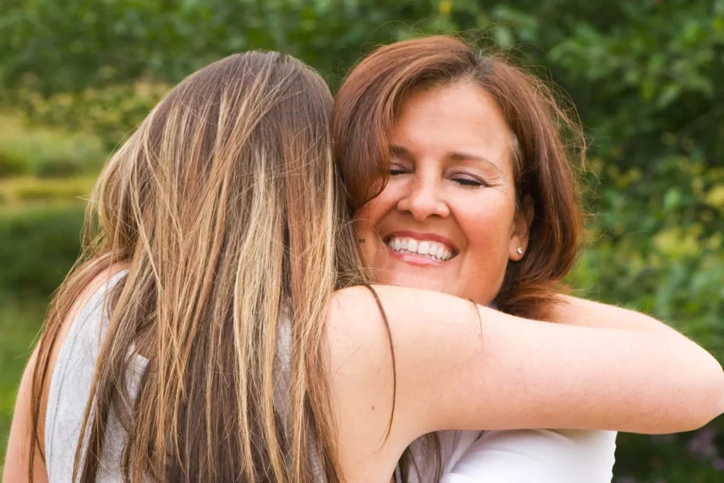 Mom hugging grateful teenaged daughter