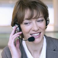 Headshot of a smiling businesswoman taking a call on her headset